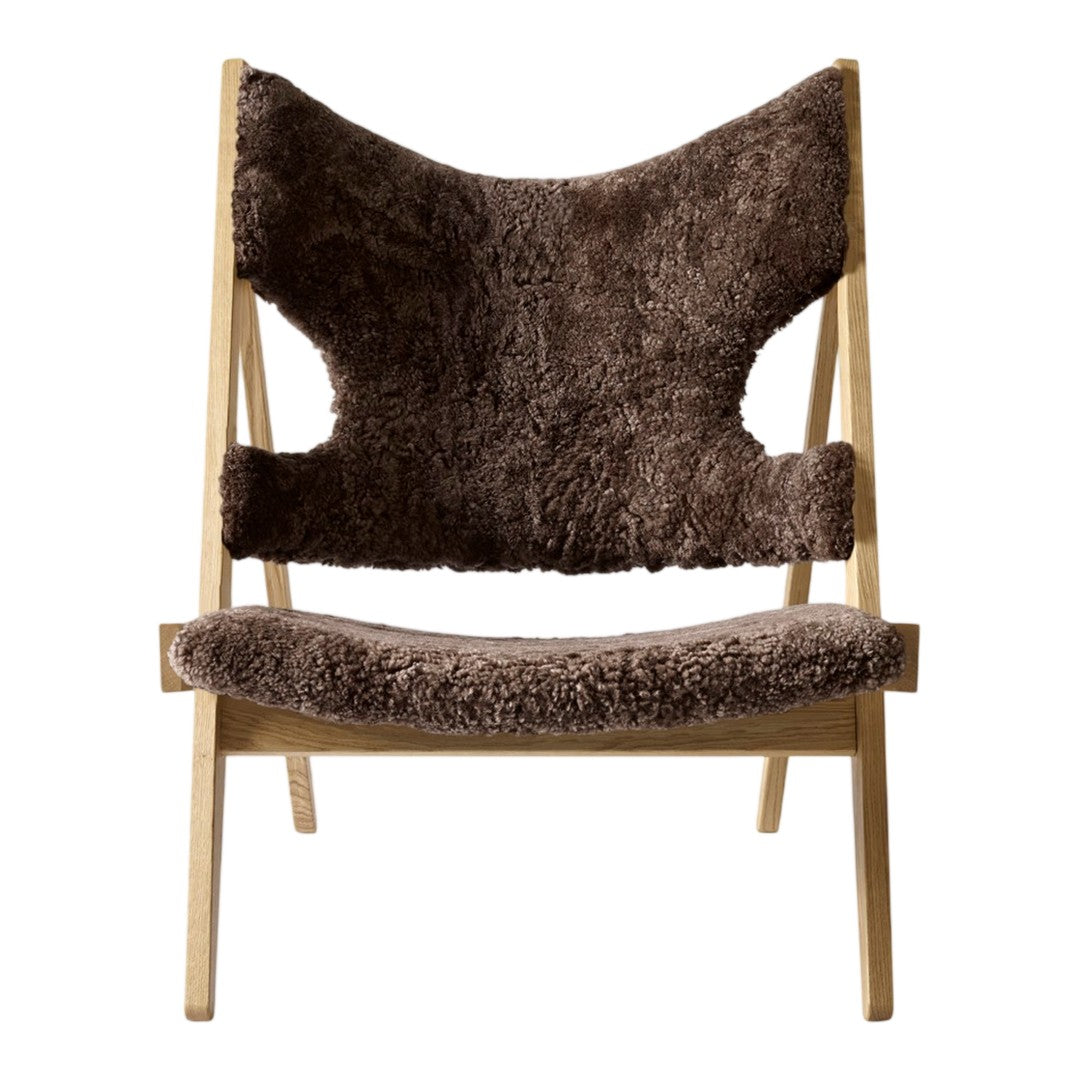 Brown shearling lounge chair with a unique pattern and natural wood frame, perfect for modern decor.