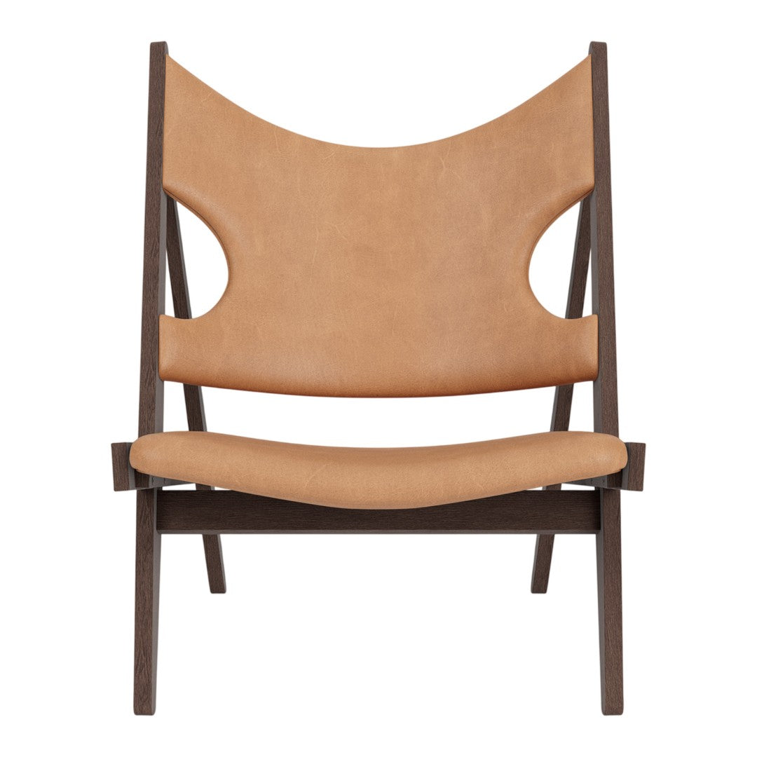 Tan leather chair with a minimalist design and dark wood frame featuring smooth lines and a modern silhouette.