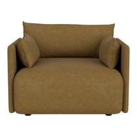 Tan upholstered modern chair with two matching pillows and a minimalist design, perfect for contemporary spaces.