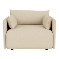 Beige armchair with soft textures and minimalist design, featuring two matching cushions for added comfort.
