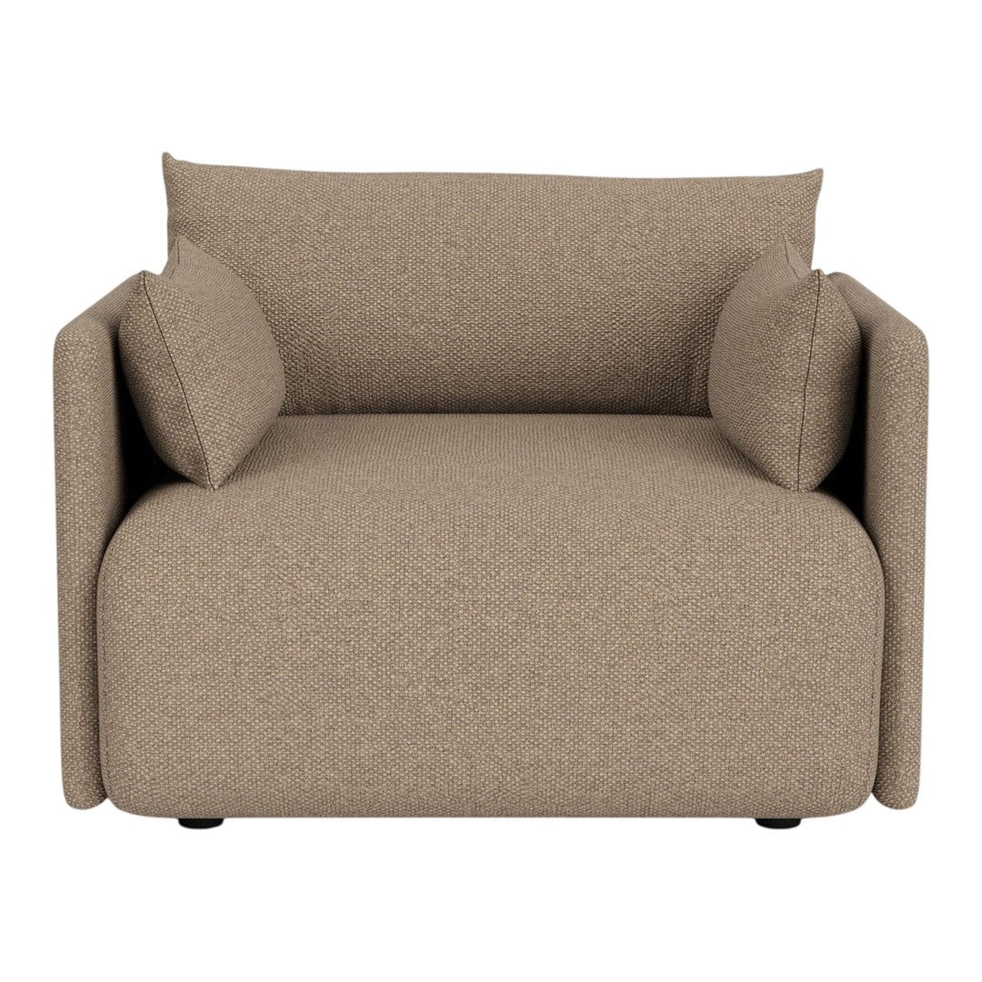 Textured beige armchair with two matching cushions, offering a cozy, modern aesthetic for any living space.