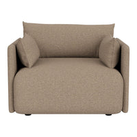 Textured beige armchair with two matching cushions, offering a cozy, modern aesthetic for any living space.