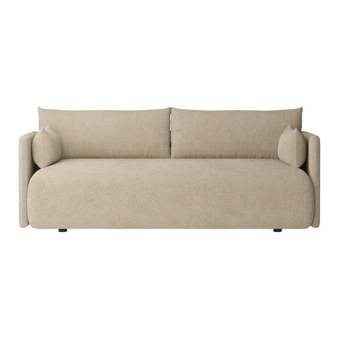 Beige upholstered sofa with smooth texture and minimalistic design, featuring round armrests and matching cushions.