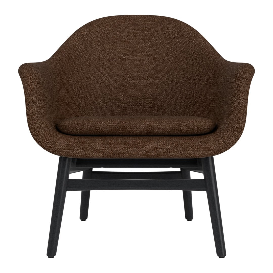 Brown upholstered lounge chair with a smooth, rounded design and black wooden legs. Perfect for modern interiors.