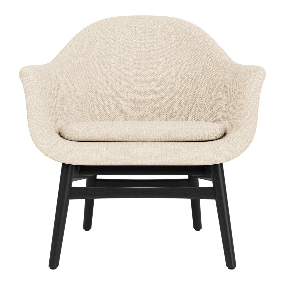 Cream upholstered armchair with a smooth texture and contrasting black wooden legs. Minimalist design for any decor.