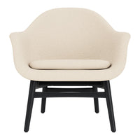 Cream upholstered armchair with a smooth texture and contrasting black wooden legs. Minimalist design for any decor.