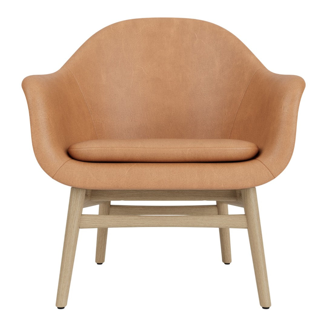 Tan leather armchair with smooth curves and a light wood base, perfect for modern decor. 