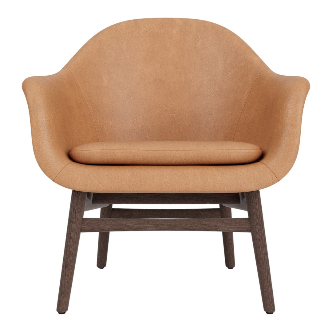 Tan upholstered chair with smooth, curved design and contrasting dark wood legs. Perfect for modern decor styles.