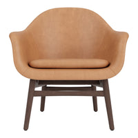 Tan upholstered chair with smooth, curved design and contrasting dark wood legs. Perfect for modern decor styles.