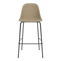 Neutral beige bar stool with a smooth, solid seat and sleek black metal legs. Modern, minimalist design.