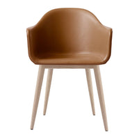 Brown leather armchair with a smooth finish and light wooden legs, featuring a minimalist design. Perfect for modern decor.