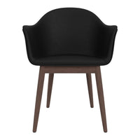 Black upholstered chair with a smooth finish and wooden legs, blending modern and minimalist design elements.