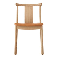 Natural wood chair with a light oak finish and a warm, tan leather seat. Simple, elegant design.