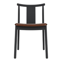 Black wooden chair with a sleek design and a contrasting brown leather seat. Minimalist aesthetic and modern appeal.