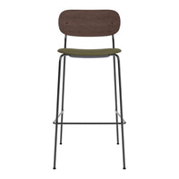 Wooden bar stool with a dark brown back, olive green seat, and sleek black metal legs, showcasing a modern design.