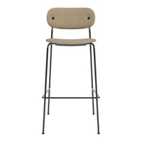 Tan upholstered bar stool with a minimalist black metal frame, featuring a simple, modern design.