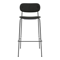 Black bar stool with a smooth, curved seat and backrest, featuring a simple, modern design and slender metal legs.