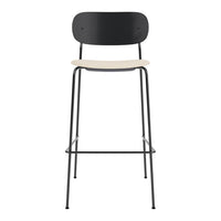 Black metal bar stool with a light wooden seat and simple, modern design. Elegant and minimalist style.
