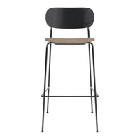 Black metal bar stool with a natural cork seat, featuring a sleek and minimalist design.