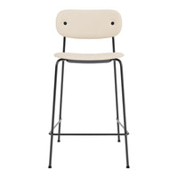 Beige upholstered bar stool with a minimalist design and black iron legs. Simple, modern aesthetic for stylish decor.
