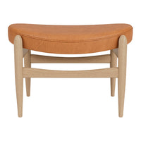 Orange upholstered bench with a curved design and light wood legs, showcasing a modern, minimalistic style.