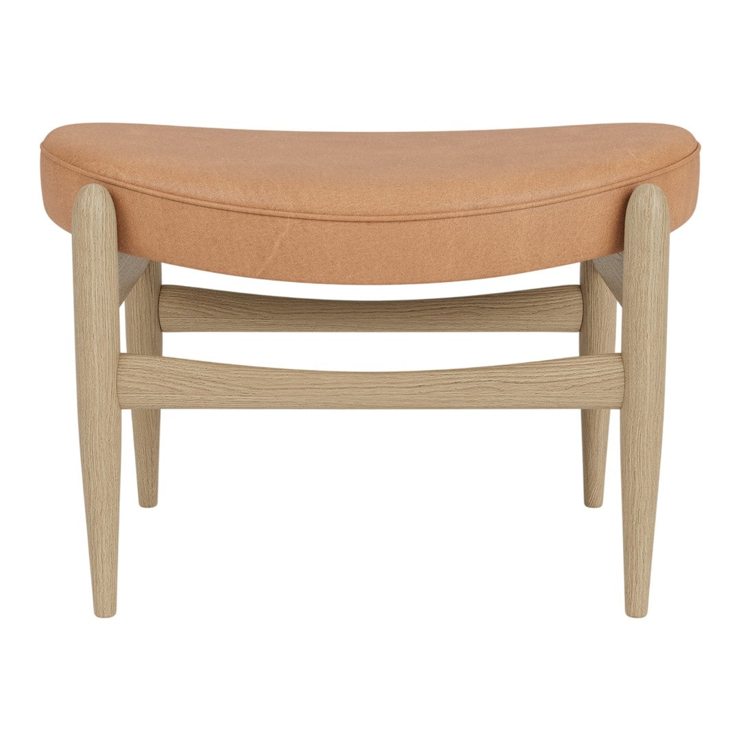 Curved orange leather seat with light wood legs, blending modern simplicity and warm color tones.