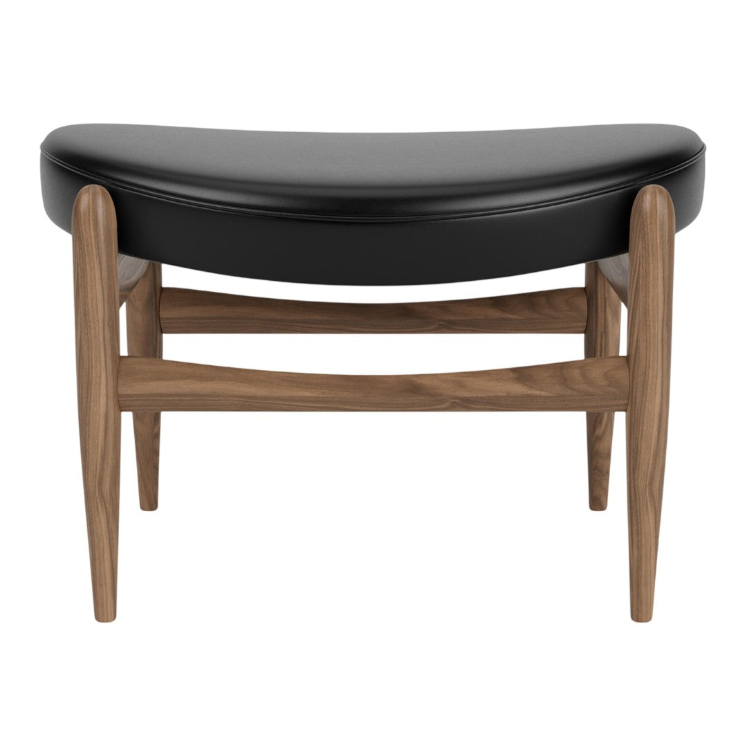 Black upholstered ottoman with a curved design and natural wood legs, featuring a sleek, modern style.