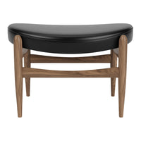 Black upholstered ottoman with a curved design and natural wood legs, featuring a sleek, modern style.