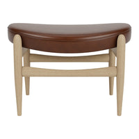 Brown curved leather upholstered ottoman with light wood legs, featuring a minimalist design and subtle natural textures.