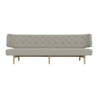 Gray tufted sofa with a sleek design and natural wood legs, creating a modern and minimalist aesthetic.