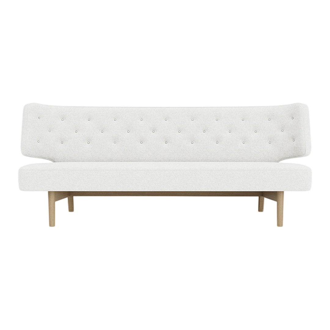 White tufted sofa with a minimalist design and wooden legs, perfect for modern decor.