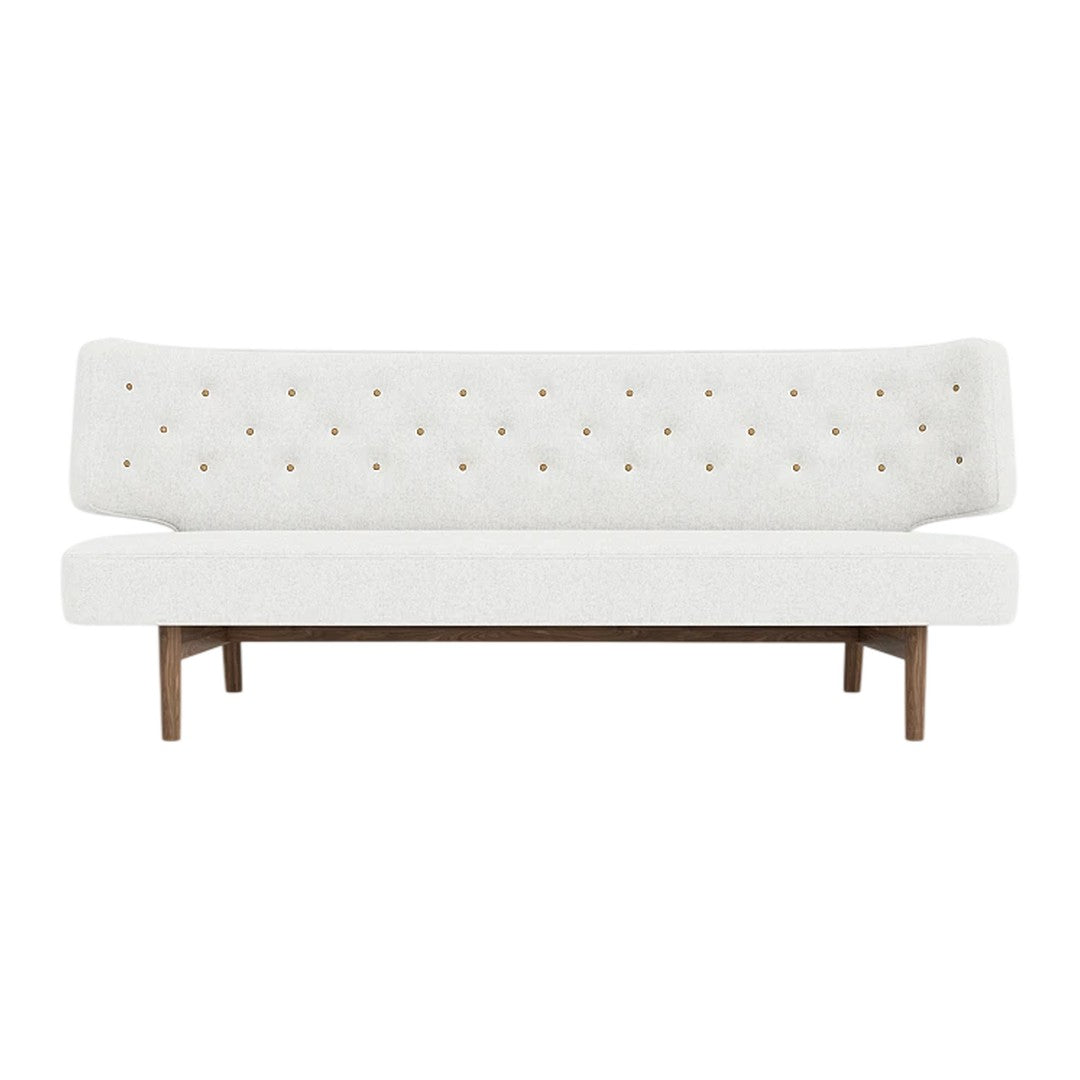 White tufted sofa with gold button accents and a wooden base, featuring a clean, minimalist design.