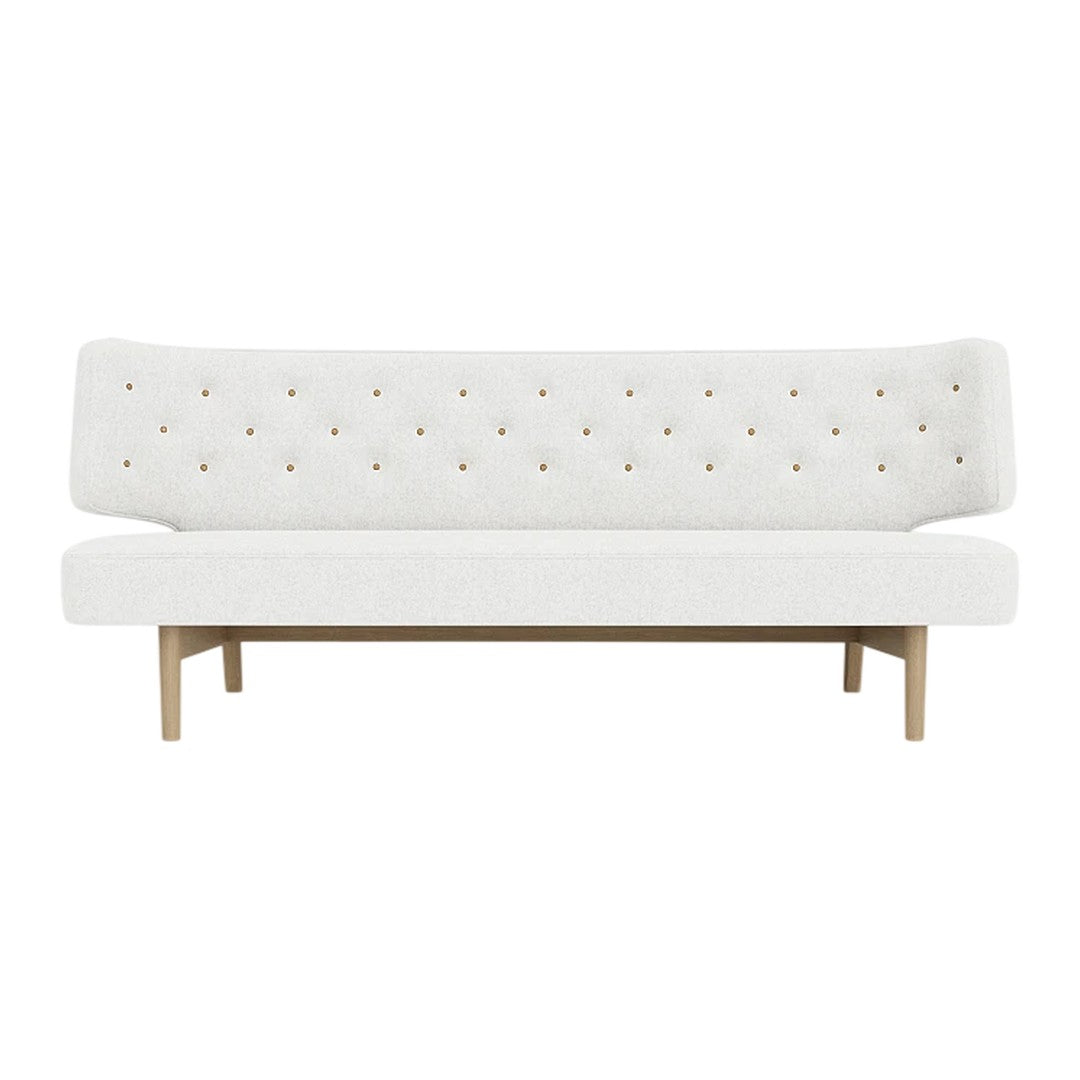 White tufted sofa with minimalistic design and subtle beige wooden legs, featuring a simple, elegant aesthetic.