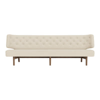 Cream upholstered sofa with tufted back and wooden legs, featuring a sleek and modern design.