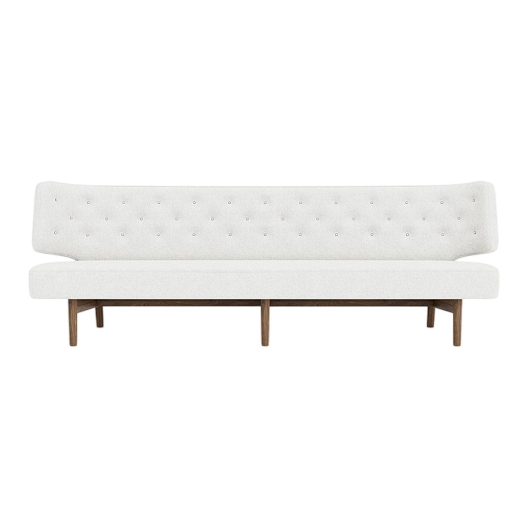 White tufted sofa with a sleek design and wooden legs, featuring a minimalist modern style.