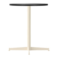 Round black tabletop with a cream-colored base in a minimalist design. Perfect for modern decor.
