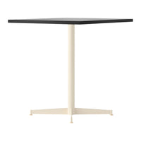 Square tabletop in black with a cream-colored pedestal, featuring a minimalist design and solid colors.