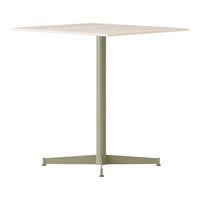 "Square tabletop in soft beige with a matte green metal base, perfect for modern decor."