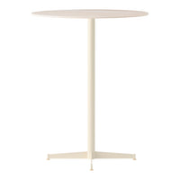 Cream-colored round table with a simple, smooth surface and a sleek metal base. Modern minimalist style.