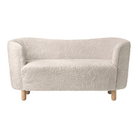 Soft, plush cream-colored sofa with rounded edges and wooden legs, perfect for modern, cozy interiors.