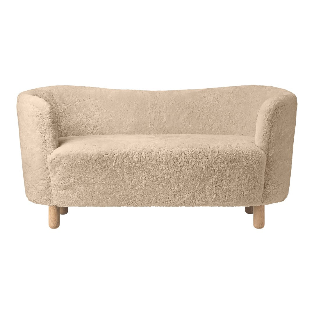 Light beige sofa with a soft, textured fabric and rounded edges, complemented by natural wooden legs.