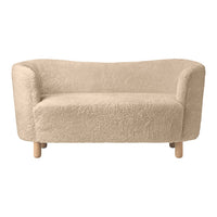 Light beige sofa with a soft, textured fabric and rounded edges, complemented by natural wooden legs.