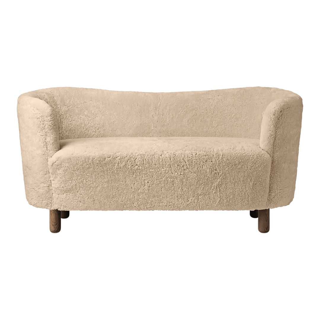 Beige curved sofa with soft, textured fabric and natural wood legs, perfect for cozy living spaces.