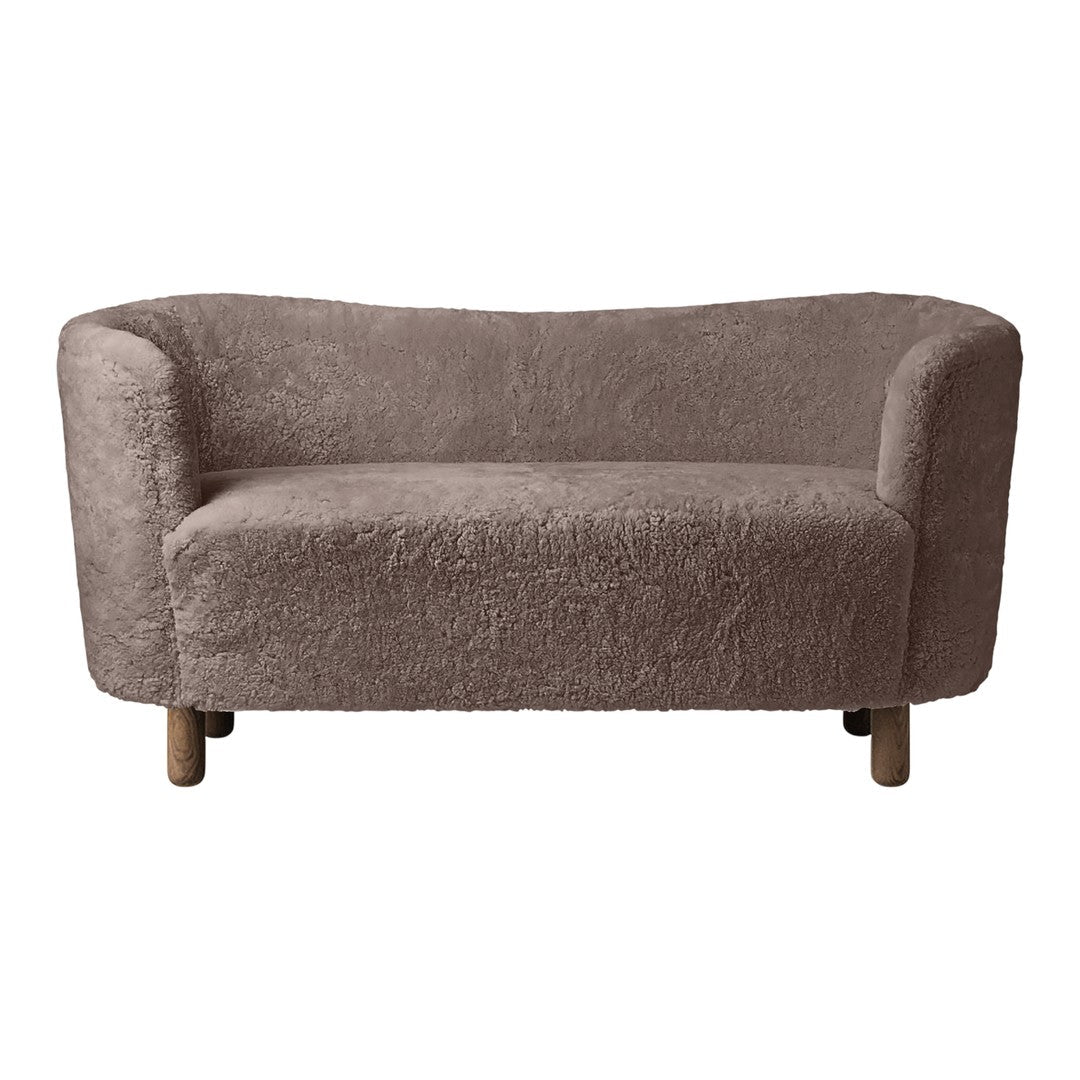 Soft, light brown sofa with a textured, fluffy fabric and rounded shape, featuring natural wooden legs.
