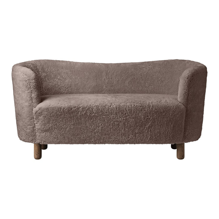 Soft, light brown sofa with a textured, fluffy fabric and rounded shape, featuring natural wooden legs.