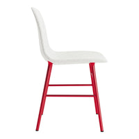 White upholstered chair with striking red metal legs, featuring a sleek and modern design.