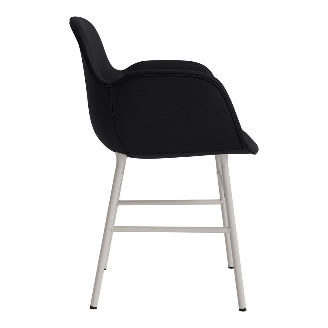 Modern black upholstered chair with sleek silver legs, showcasing a minimalist design and subtle curves.