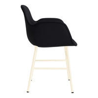 Black upholstered chair with minimalist design and creamy white legs, highlighting modern style and contrast.