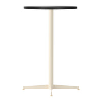 Minimalist round table with a black top and cream-colored base, featuring a sleek, modern design.