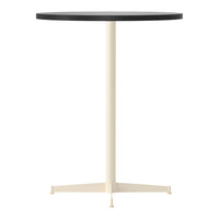 Round table featuring a sleek black top and a minimalist cream-colored base, perfect for modern decor.